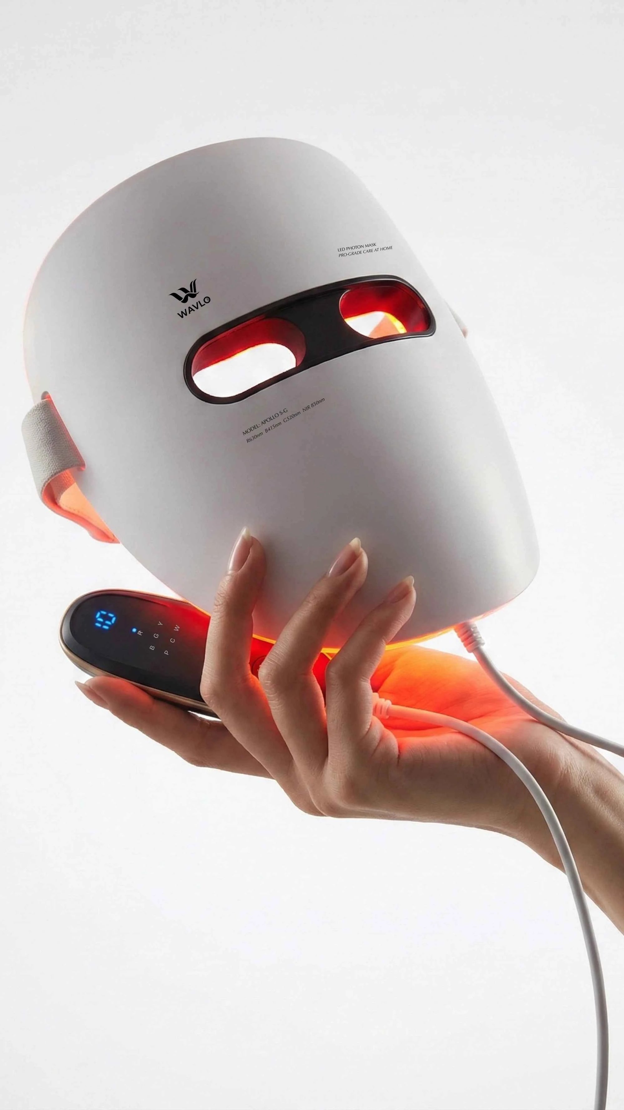 White Apollo SG LED face mask with red lights held by a hand on a white background