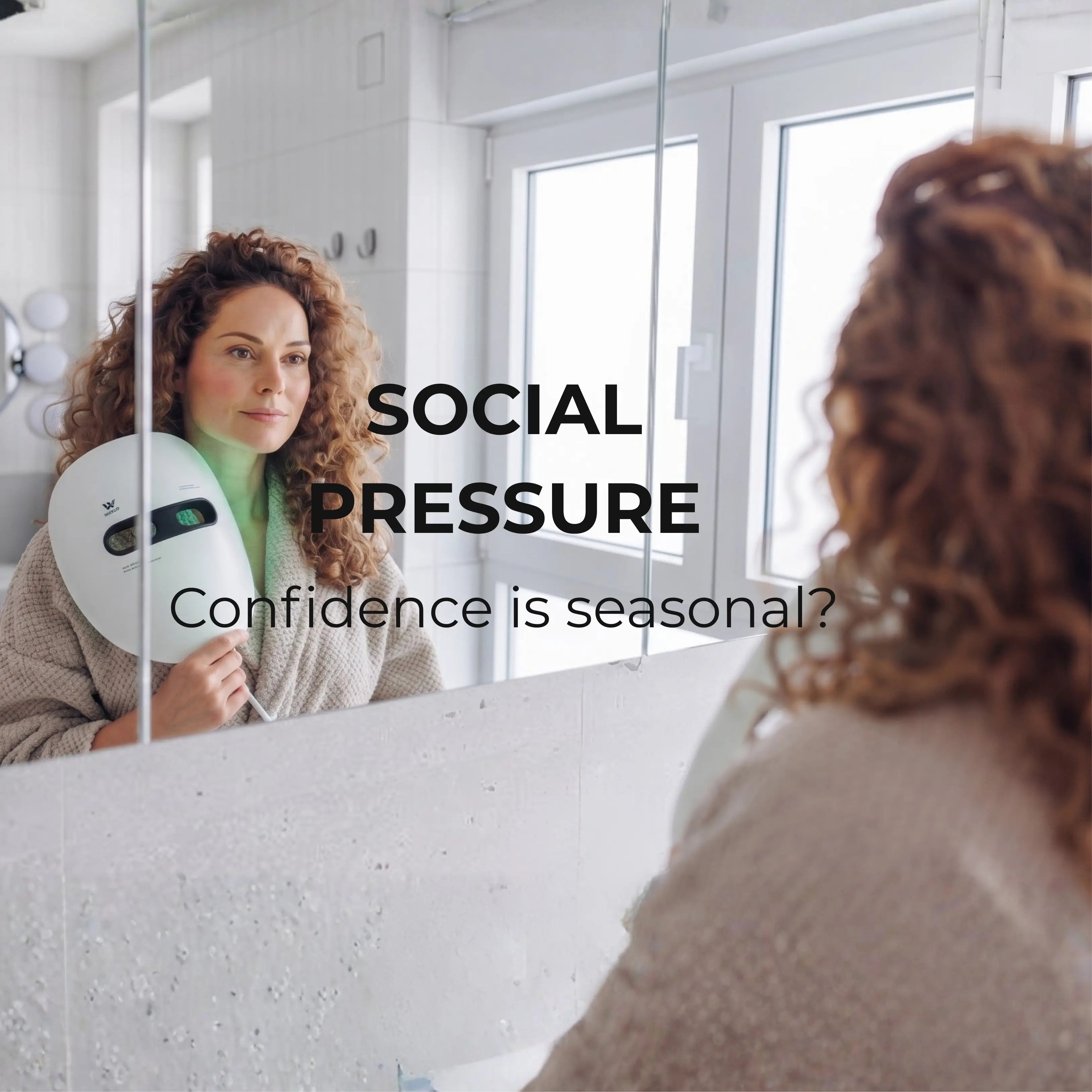 A woman in a bathroom holds a white led face mask - WAVLO Apollo SG in front of a mirror, with overlaid text reading 'SOCIAL PRESSURE' and 'Confidence is seasonal?'.